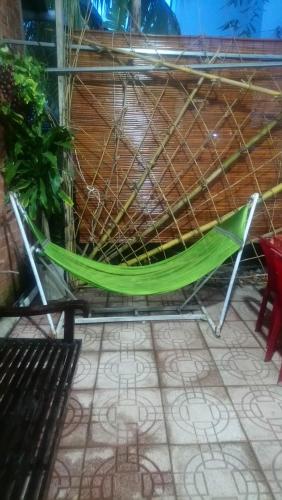 a green hammock sitting on a patio at BenTrestay in Giồng Tú Ðiền