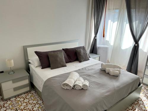 a bedroom with a large white bed with towels on it at Sorrento's Carme family big appartament in Sorrento