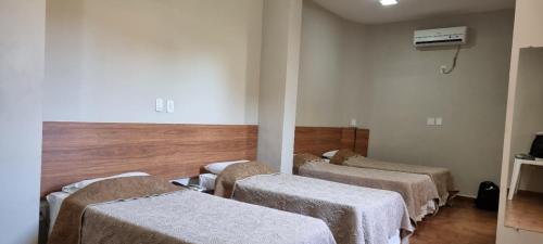 a hospital room with four beds in a row at Hotel Pouso Novo in Matão
