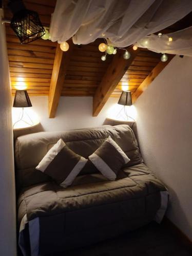 un canapé dans une pièce avec deux lampes dans l'établissement Le Loft Doré, à Ustou