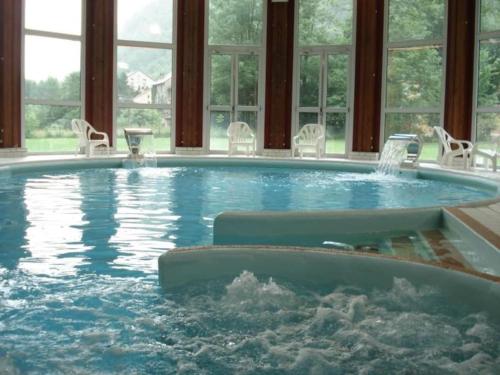 une grande piscine avec des chaises et une fontaine dans l'établissement Le Loft Doré, à Ustou