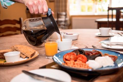 a person is pouring coffee into a plate of food at The Wellington Heifer in Northallerton