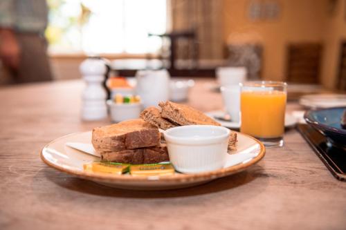 ein Teller mit Essen, Brot und einem Glas Orangensaft in der Unterkunft The Wellington Heifer in Northallerton