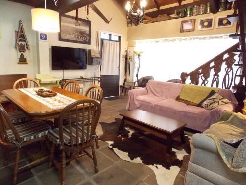 ein Wohnzimmer mit Tisch und Couch in der Unterkunft Sobrado no Centro de Canela in Canela