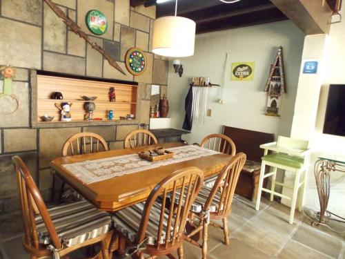 a dining room with a wooden table and chairs at Sobrado no Centro de Canela in Canela