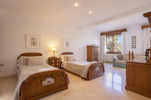 a bedroom with two beds and a couch at Villa Can Gual Family Suite in Inca
