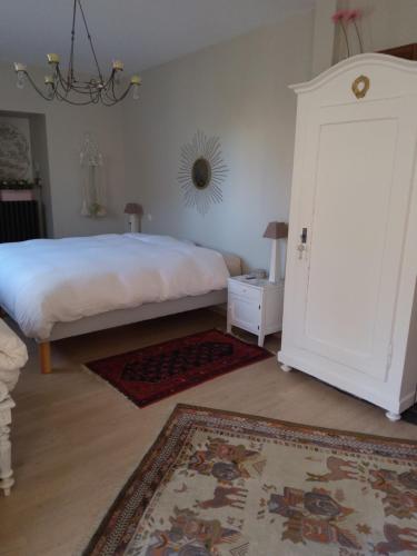 Schlafzimmer mit einem Bett und einer Tür mit einem Teppich in der Unterkunft Le jardin des roses in Colmar