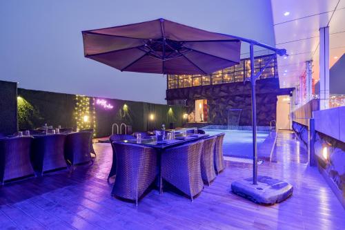 a restaurant with a table with chairs and an umbrella at Treebo Winsome Banquet And Resort in Rānchī