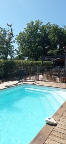 - une piscine avec un objet blanc sur une terrasse en bois dans l'établissement Agréable maison piscine chauffée et spa à Andernos, à Andernos-les-Bains
