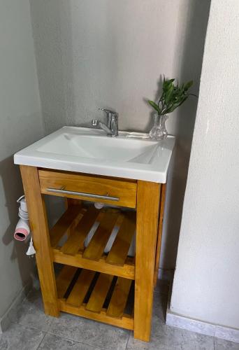 a bathroom sink with a wooden stand with aacteduanauana on it at Dto III Temperley in Temperley