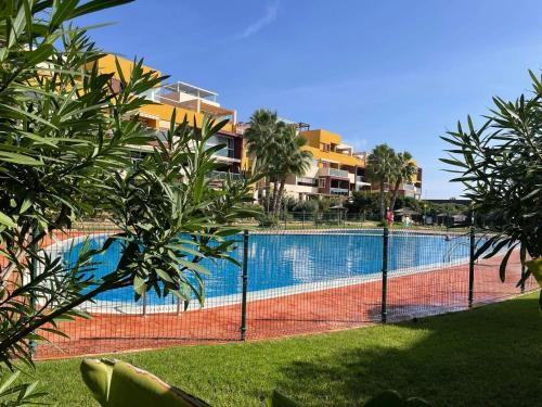 una pista de tenis frente a una piscina en Casa Palmera - El Bosque - Playa Flamenca en Playa Flamenca