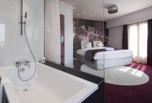 a bathroom with a bed and a tub and a sink at Mercure Paris Place d'Italie in Paris