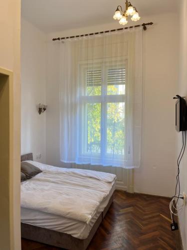 a bedroom with a bed and a window at Apartments & Room - Korzo in Sombor