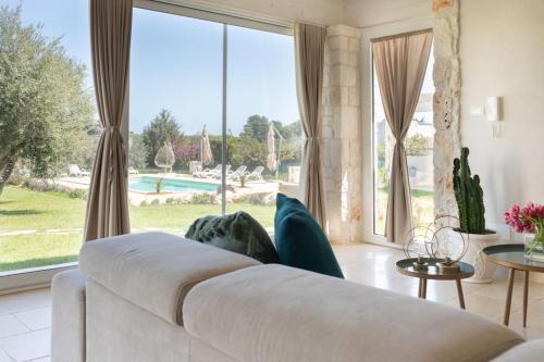a living room with a white couch and a large window at Tenuta Traghetto in Ostuni