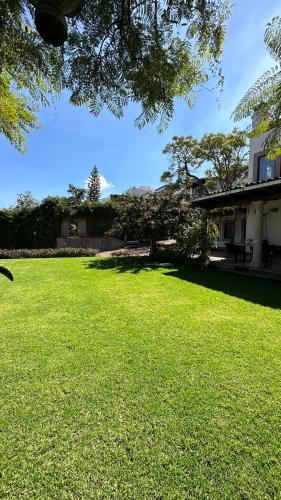 a large grassy yard with a house in the background at Maja Hotel Boutique in Morelia