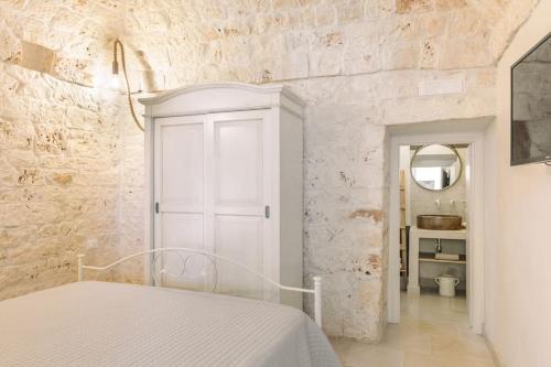 a bedroom with a bed and a white wall at Tenuta Traghetto in Ostuni