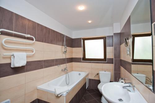 un bagno con vasca, WC e lavandino di Bell Tower at BlackSeaRama Golf&Villas a Balchik