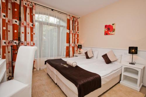 una camera da letto con un letto bianco e una finestra di Bell Tower at BlackSeaRama Golf&Villas a Balchik