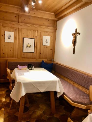 a dining room with a table and a cross on the wall at Haus Hubertus Sommerpreise incl Sommercard in Jerzens