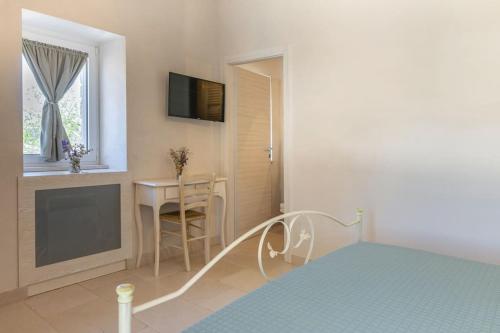 a bedroom with a bed and a table and a window at Tenuta Traghetto in Ostuni