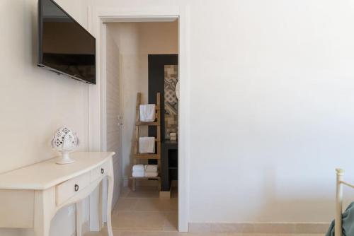 a living room with a television and a white table at Tenuta Traghetto in Ostuni