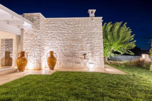 three vases sitting on the side of a brick wall at Tenuta Traghetto in Ostuni