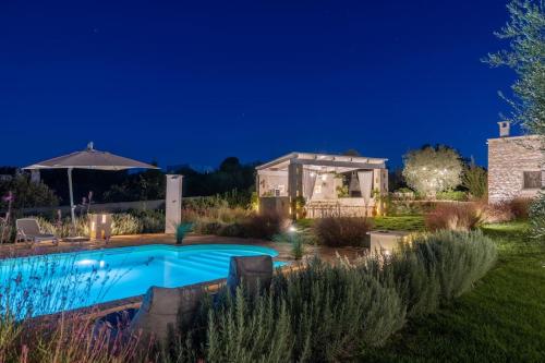 a backyard with a swimming pool at night at Tenuta Traghetto in Ostuni