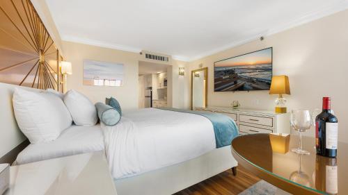 a bedroom with a bed and a table with a wine glass at La Mer Beachfront Resort in Cape May