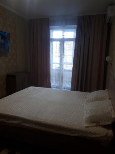 a bedroom with a white bed and a window at comfortable apartment in Chişinău