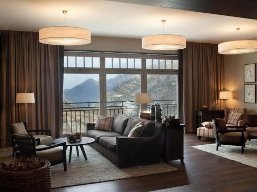 a living room with a couch and a large window at Historisches Alpinhotel Grimsel Hospiz in Grimsel Hospiz