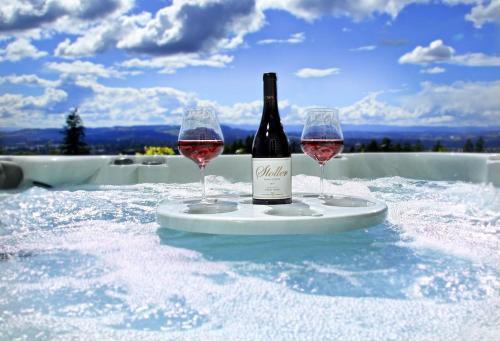 eine Flasche Wein und zwei Weingläser auf dem Tisch in der Unterkunft Luxury Wine Country Estate in Newberg