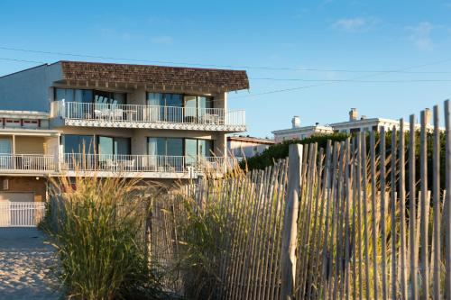 a building with a fence in front of it at La Mer Beachfront Resort in Cape May