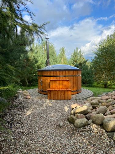 a wooden building with a hot tub in a garden at Dolina Bella in Gołubie