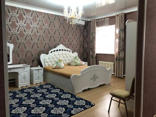 una camera per bambini con un letto bianco e una sedia di Гостиница NUR a Aralʼsk