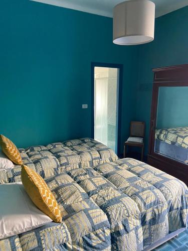 a bedroom with two beds and a blue wall at Albergo Bergagna in Pont Canavese