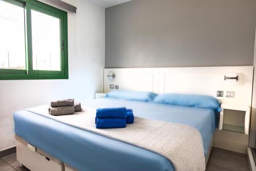 um quarto com 2 camas e lençóis azuis em Sunshine San Valentin em Corralejo