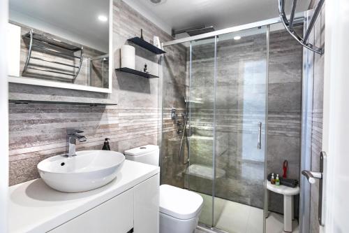 uma casa de banho com um lavatório branco e um chuveiro em Sunshine San Valentin em Corralejo