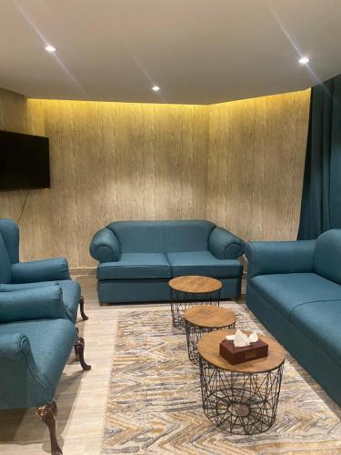 una sala de estar con sofás y mesas azules en فندق المنصور, en Aḑ Ḑabbīyāt al Janūbīyāt