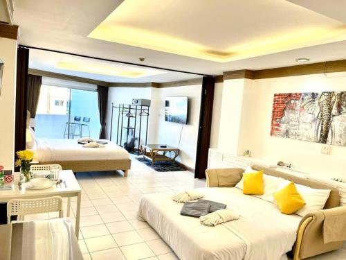 um quarto de hotel com duas camas e um sofá em Patong Beach Gardens - Pool Fast WiFi Smart TVs em Praia de Patong