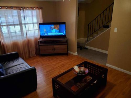 a living room with a couch and a television at #2BR Cozy Villa - Mins to Historic STM Amusement Park! in Stone Mountain