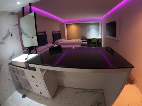 a living room with a large bathtub with purple lights at WeEnjoy Hotels Grand Prix Aeropuerto CDMX in Mexico City