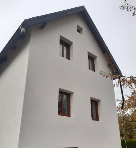 a white building with four windows on it at Odal Hawaii sro ubytování vzdělávání in Pěnčín