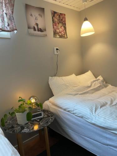 a bedroom with a bed and a table with a night stand at Central floor with sauna, wi-fi and own entrance in Mariehamn