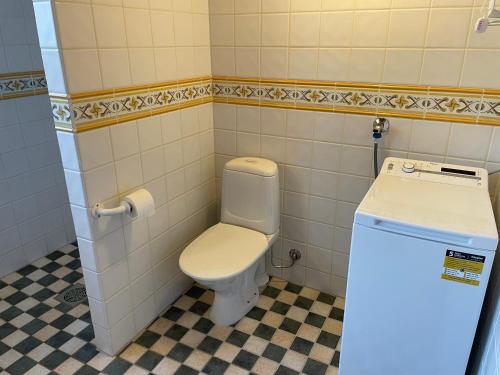 a bathroom with a toilet and a small refrigerator at Central floor with sauna, wi-fi and own entrance in Mariehamn