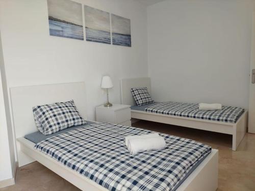 Cette chambre blanche comprend 2 lits. dans l'établissement Beautiful new apartment with direct sea view, FIRST LINE!!, à Manilva