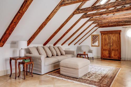 una sala de estar con un sofá blanco y techos de madera. en Hotel Nerudova 211, en Praga