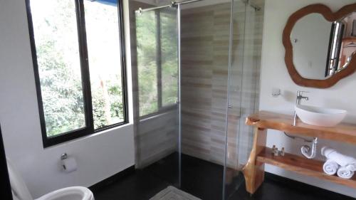 a bathroom with a sink and a glass shower at Las cabañas del escobo-CABAÑA GUACAMAYAS in Nimaima