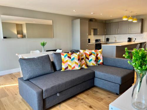 a living room with a couch and a kitchen at SoHot Stays Sea View Apartments in Kent