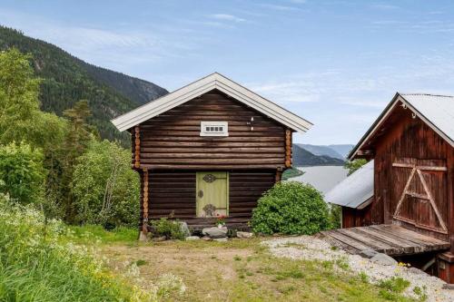 an old house and a barn on a hill at Stamp and sauna! Small farm with fantastic view! in Favang