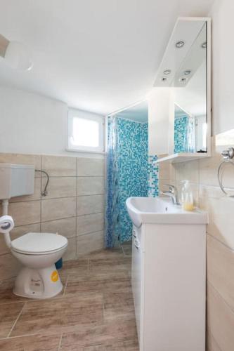 a bathroom with a toilet and a sink and a mirror at beautiful bay house Duga in Okrug Gornji